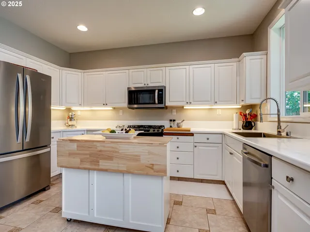 a kitchen with granite countertop a refrigerator sink and microwave
