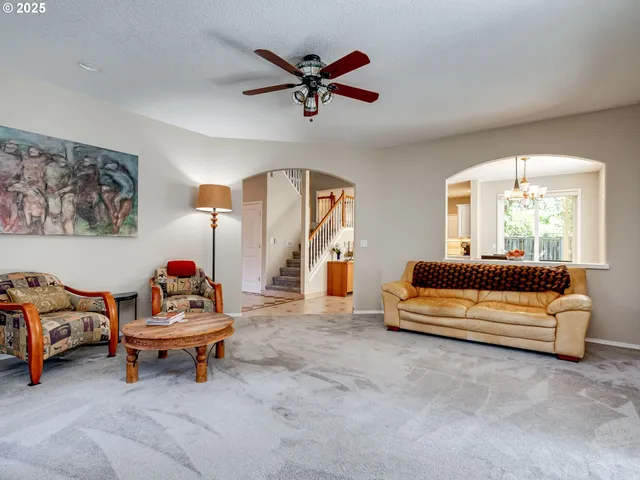a living room with furniture and a ceiling fan