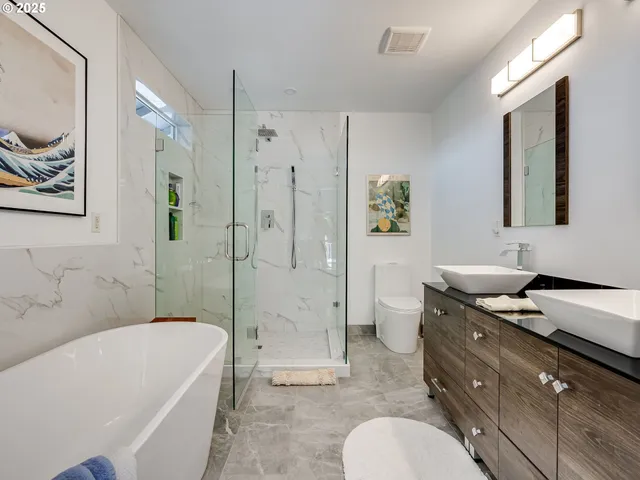 a bath room with a toilet a bath tub and a shower