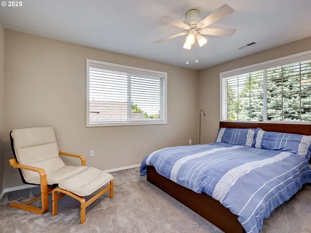 a bedroom with a bed a chair and a chandelier