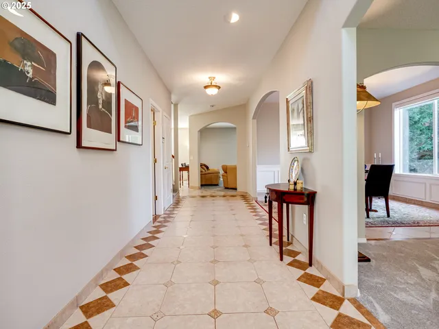 a view of a hallway with couches and dining table
