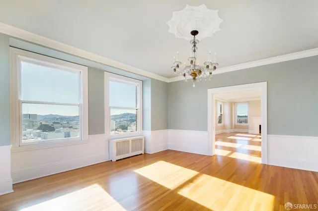 a view of a room with wooden floor and chandelier