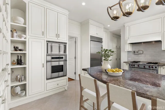 a kitchen with stainless steel appliances kitchen island granite countertop a table and chairs in it