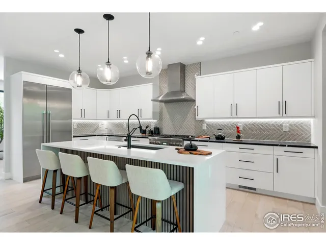 a kitchen with granite countertop a sink a stove a dining table and chairs