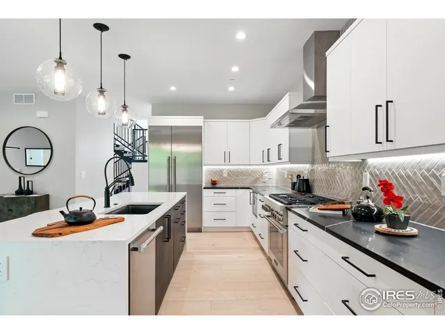 a kitchen with kitchen island stainless steel appliances a sink a stove and cabinets