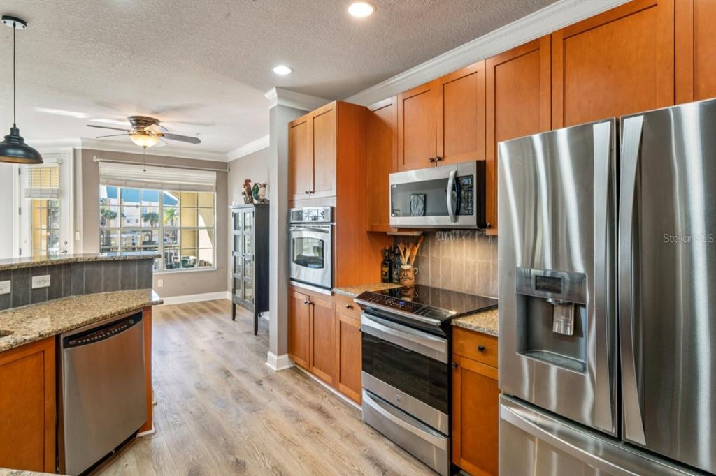 6319 Sunset Bay Circle Apollo Beach, FL 33572 - Photo 12 of 87 a kitchen with stainless steel appliances granite countertop a refrigerator stove and oven