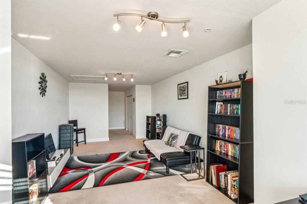 6319 Sunset Bay Circle Apollo Beach, FL 33572 - Photo 36 of 87 a living room with lots of furniture and a book shelf