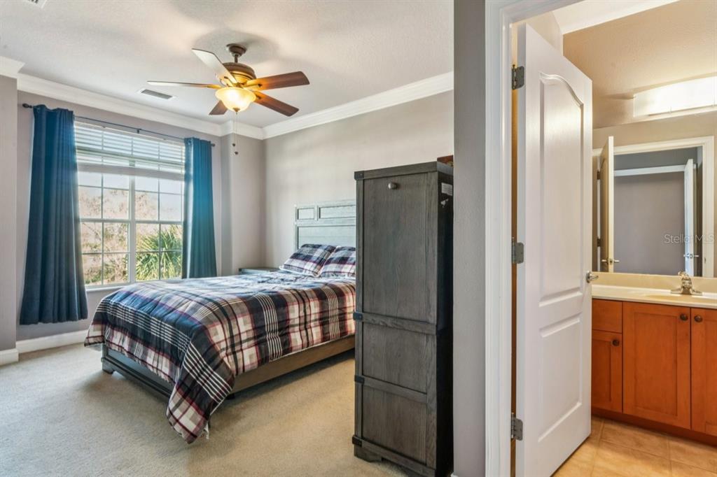 6319 Sunset Bay Circle Apollo Beach, FL 33572 - Photo 49 of 87 a bedroom with a bed and a chandelier