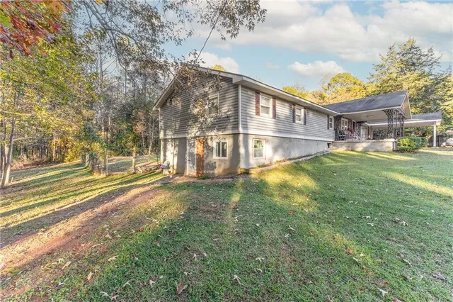 a view of an house with backyard and trees