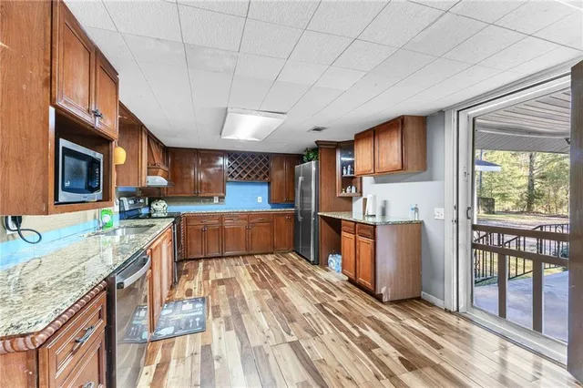 a large kitchen with stainless steel appliances granite countertop a stove a sink dishwasher and a refrigerator