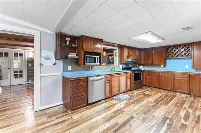 a kitchen with stainless steel appliances granite countertop a stove sink and cabinets