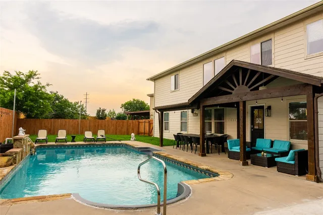a view of a house with swimming pool and sitting area