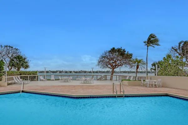 a view of a lake with a bench and trees in the background