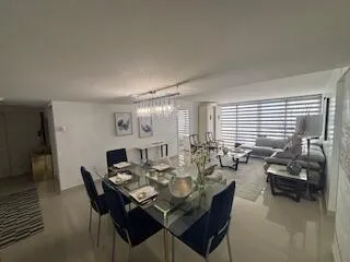 a view of a dining room and livingroom with furniture wooden floor and a rug