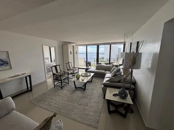 a living room with furniture and large windows