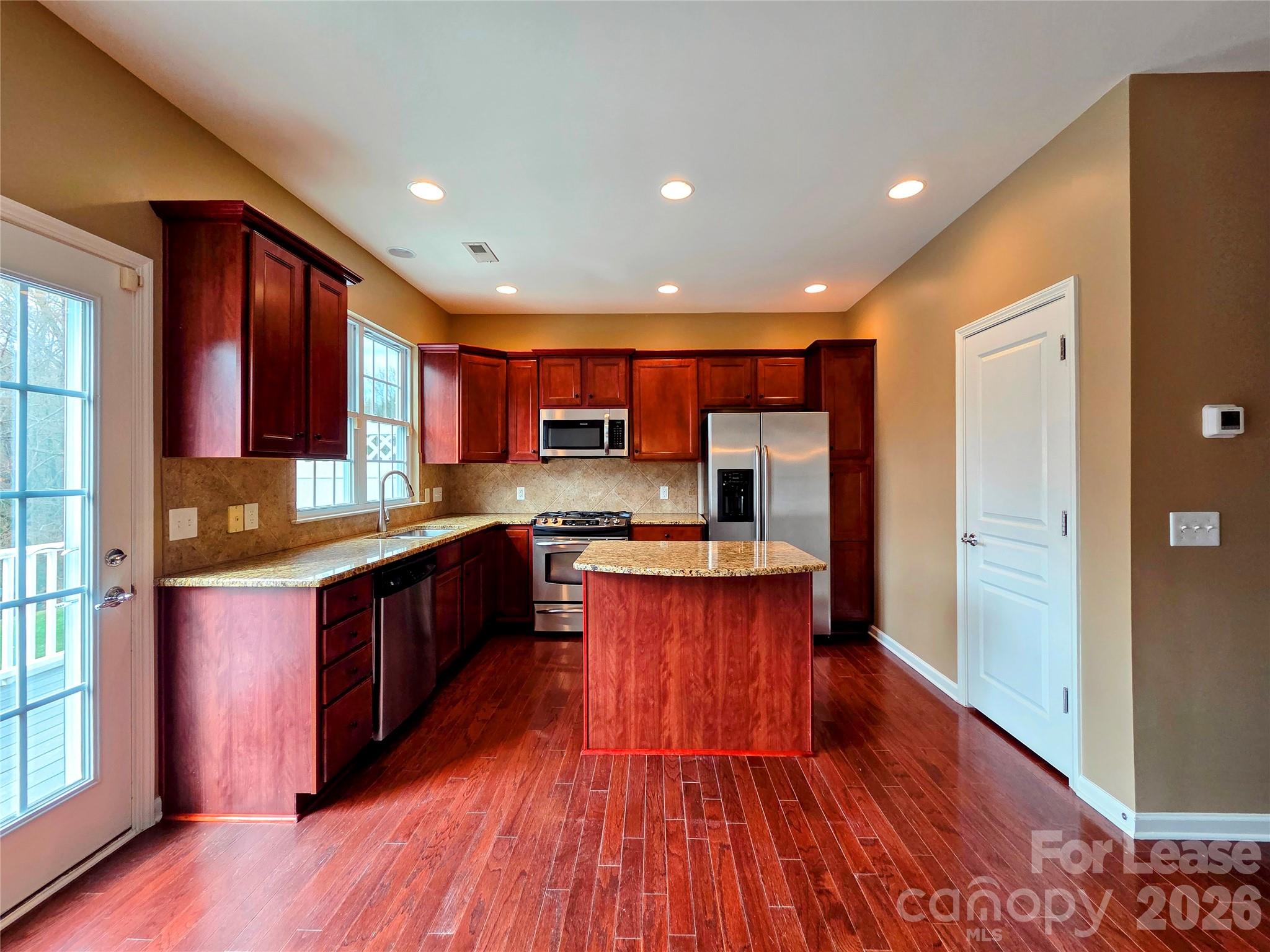 1114 Drayton Court Fort Mill, SC 29708 - Photo 11 of 31 a large kitchen with stainless steel appliances wooden floors and wooden cabinets