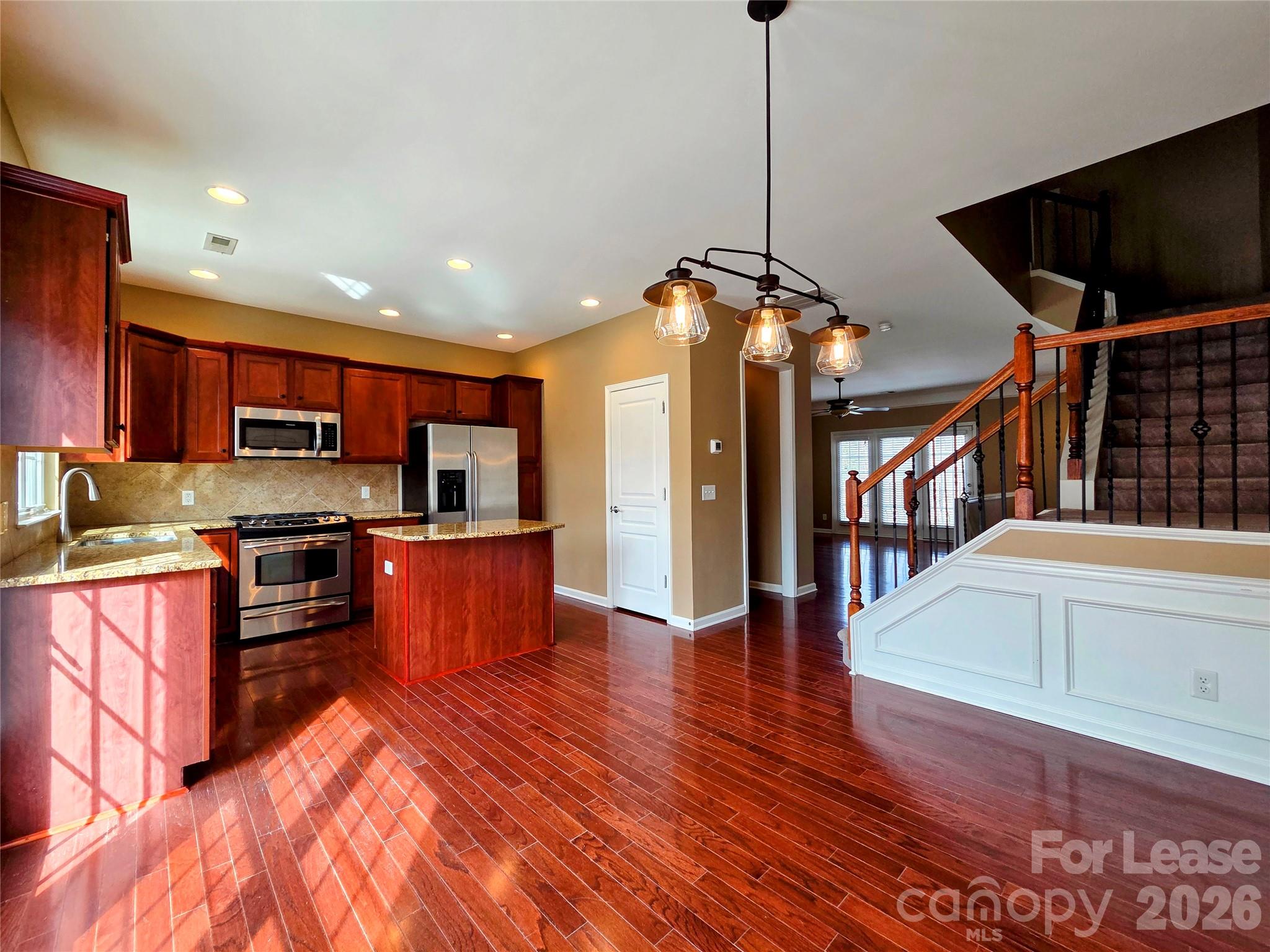1114 Drayton Court Fort Mill, SC 29708 - Photo 13 of 31 a kitchen with stainless steel appliances granite countertop a refrigerator a sink dishwasher a stove and a dining table with wooden floor