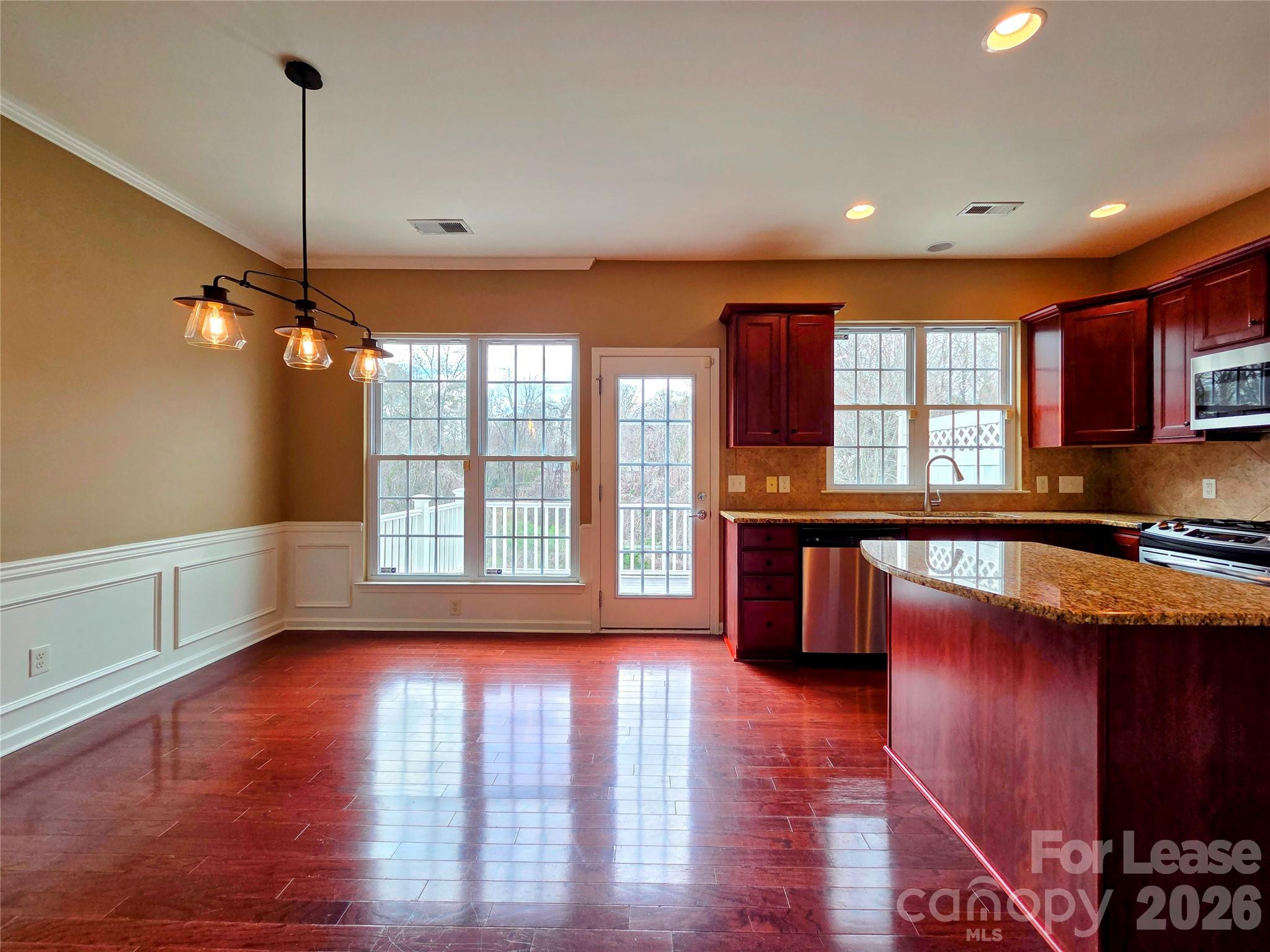 1114 Drayton Court Fort Mill, SC 29708 - Photo 7 of 31 a open kitchen with stainless steel appliances granite countertop a stove a sink wooden floor and a large window
