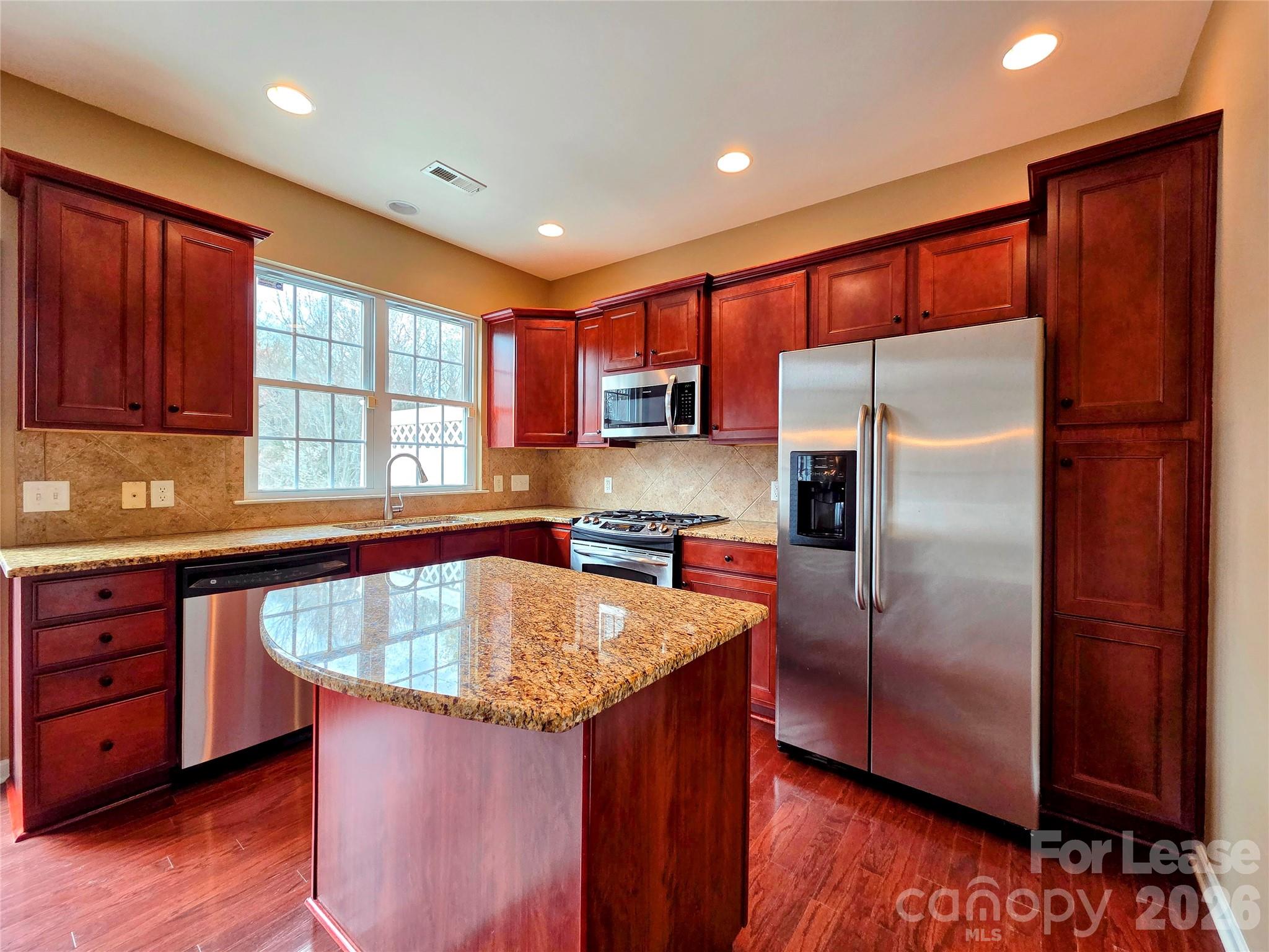 1114 Drayton Court Fort Mill, SC 29708 - Photo 8 of 31 a kitchen with stainless steel appliances granite countertop a refrigerator a sink dishwasher and wooden cabinets with wooden floor