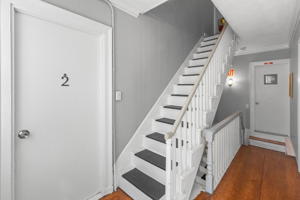 40 Middle Street, Unit 2 Gloucester, MA 01930 - Photo 4 of 21 a view of staircase with wooden floor and lots of frames on wall