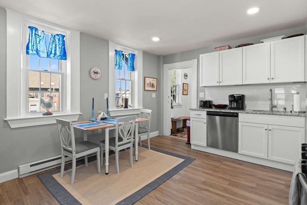 40 Middle Street, Unit 2 Gloucester, MA 01930 - Photo 10 of 21 a kitchen with stainless steel appliances granite countertop a table chairs sink and cabinets