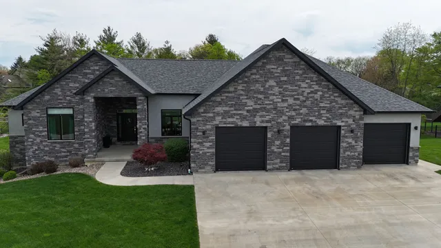 a front view of a house with a garden and yard