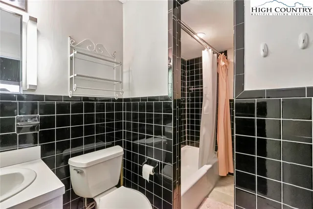 a bathroom with a toilet a sink a mirror and a shower