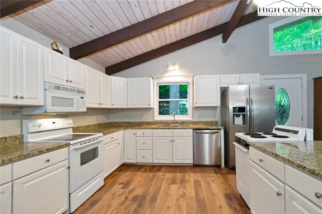 a kitchen with granite countertop stainless steel appliances cabinets a sink and a counter top space