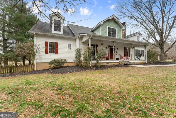 a front view of a house with swimming pool and porch with furniture