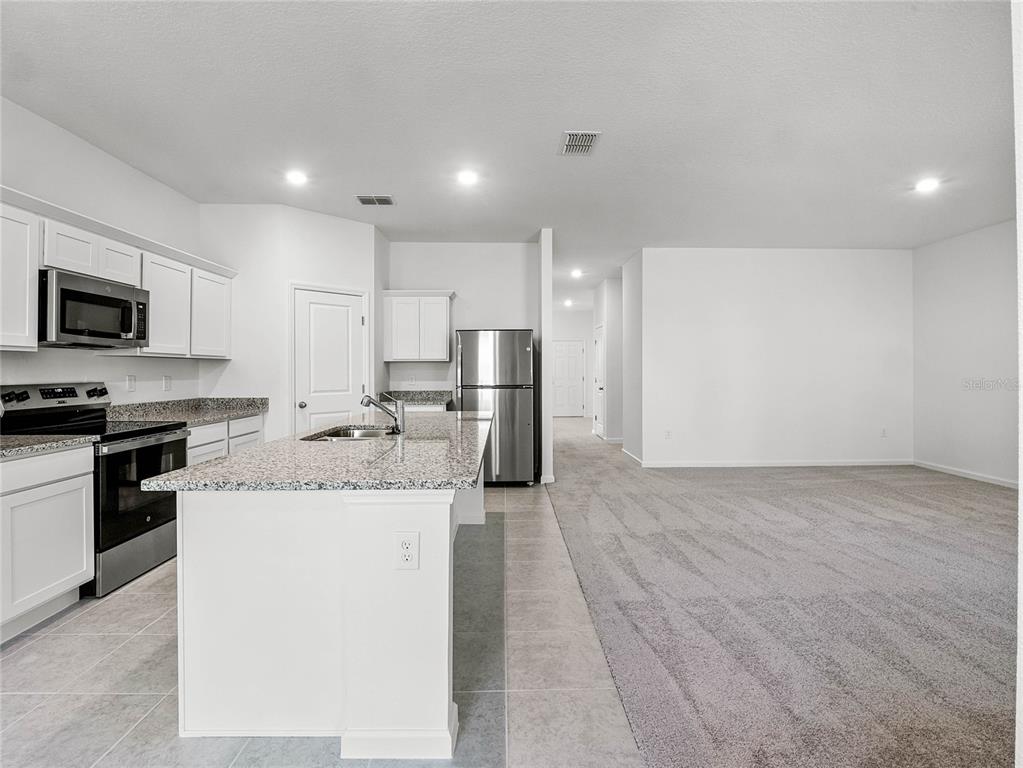 2202 Raven Rdg Road Clermont, FL 34715 - Photo 12 of 37 a kitchen with stainless steel appliances granite countertop a stove and a refrigerator