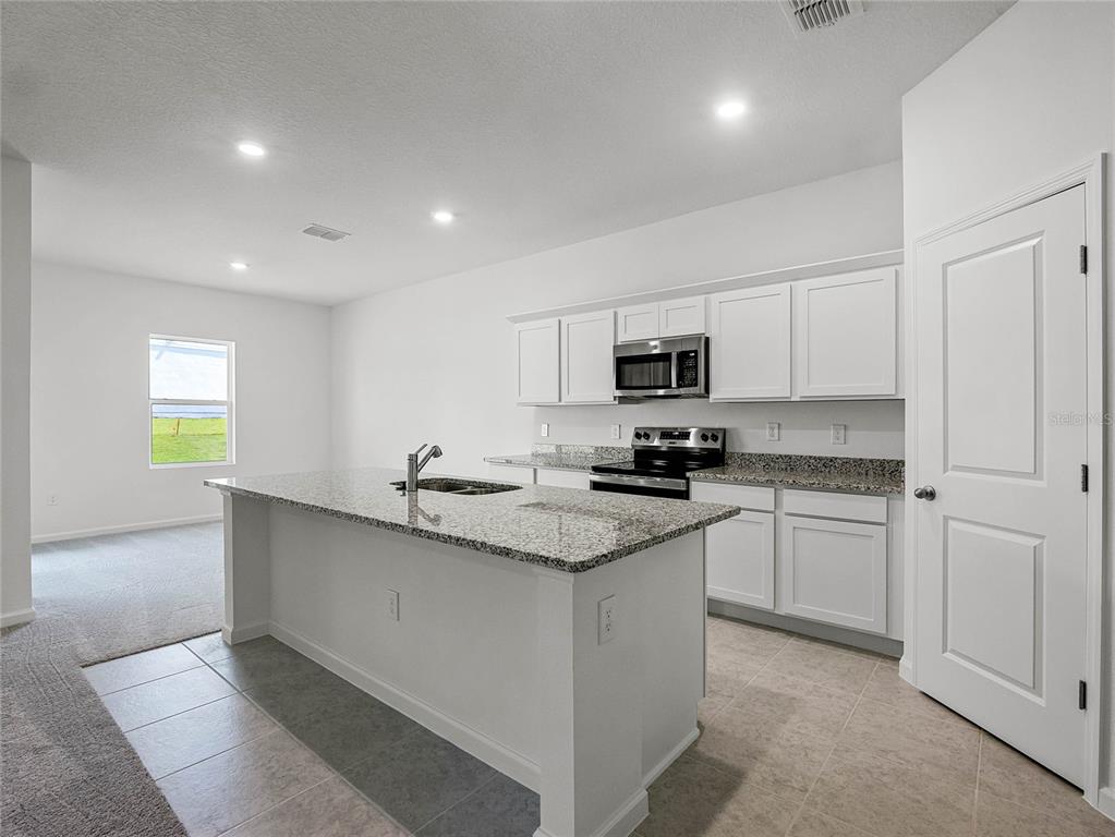 2202 Raven Rdg Road Clermont, FL 34715 - Photo 8 of 37 a kitchen with granite countertop white cabinets and appliances