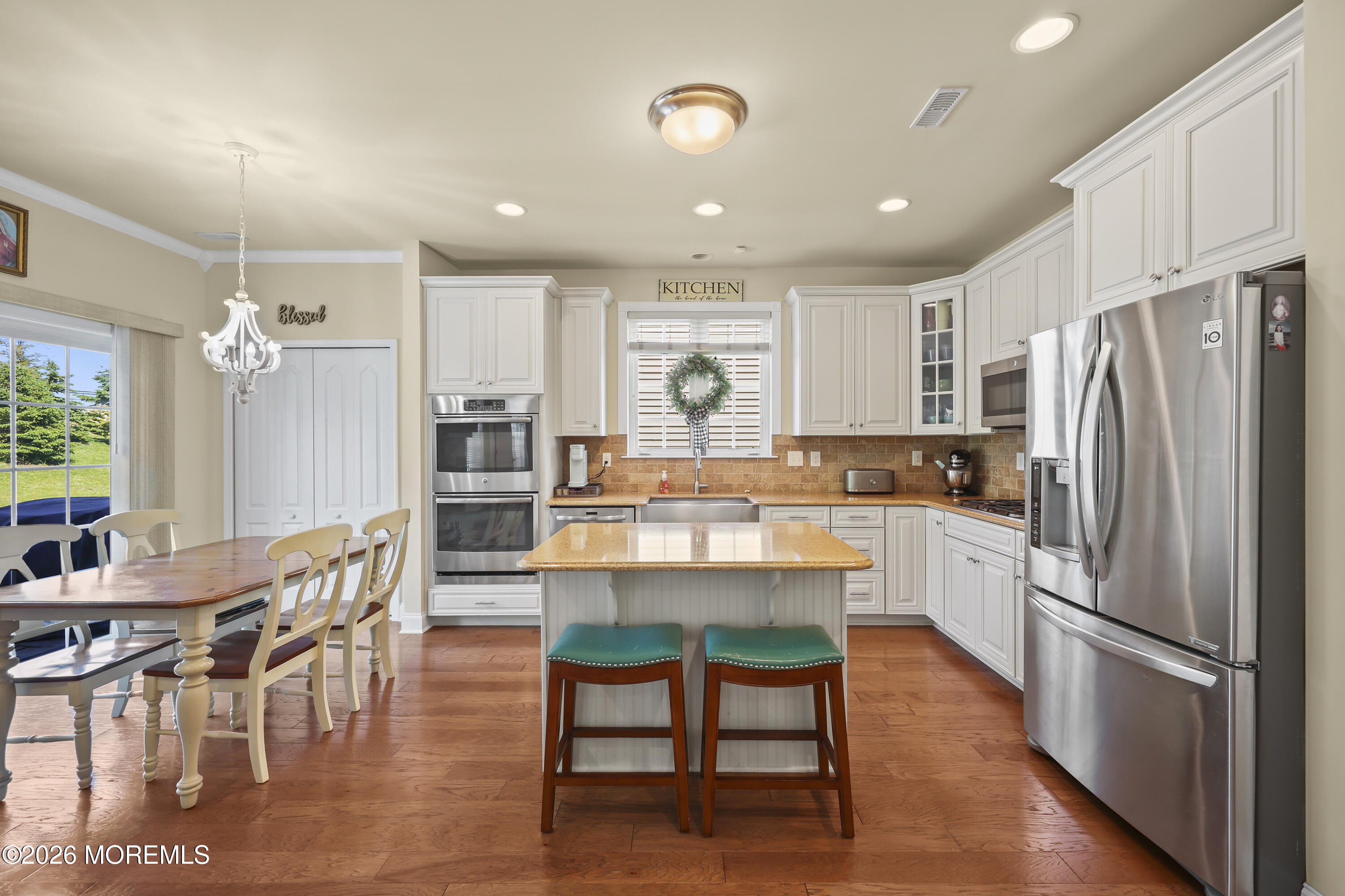 51 Mason Drive Jackson, NJ 08527 - Photo 12 of 39 a kitchen with stainless steel appliances granite countertop a refrigerator a stove a kitchen island and chairs with wooden floor