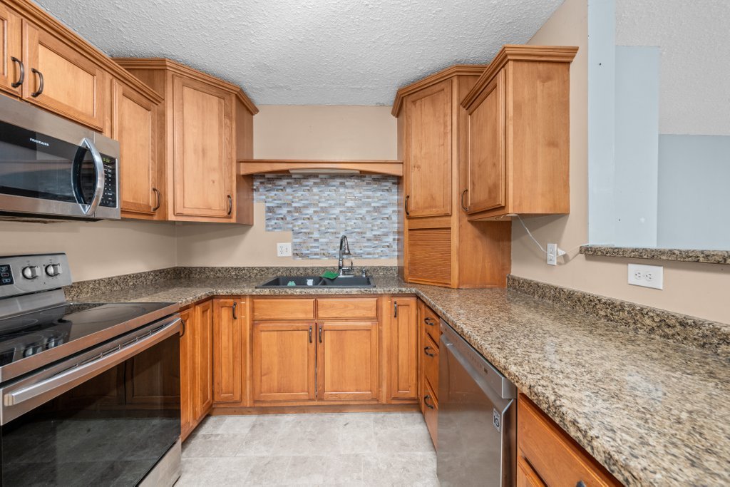 1500 9th Street Northwest Clinton, IA 52732 - Photo 16 of 28 a kitchen with stainless steel appliances granite countertop a sink stove and microwave