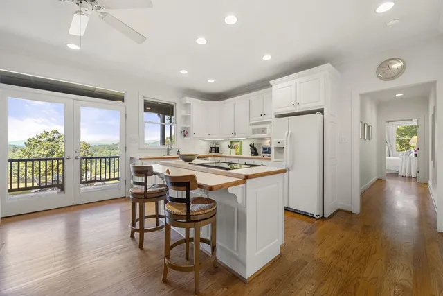 a kitchen with a stove a sink dishwasher and a refrigerator with wooden floor