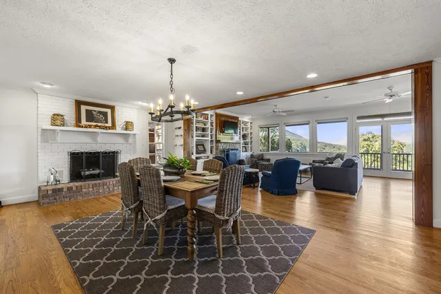 a view of a dining room with furniture a chandelier and wooden floor