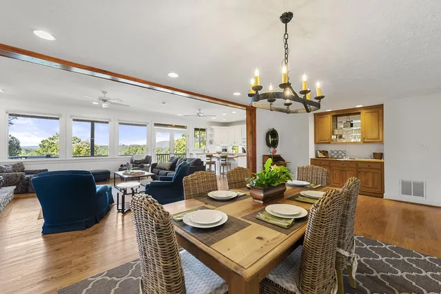 a view of a dining room with furniture a chandelier and wooden floor