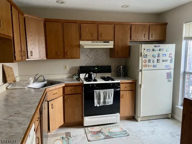 a kitchen with stainless steel appliances granite countertop a stove a refrigerator and a sink