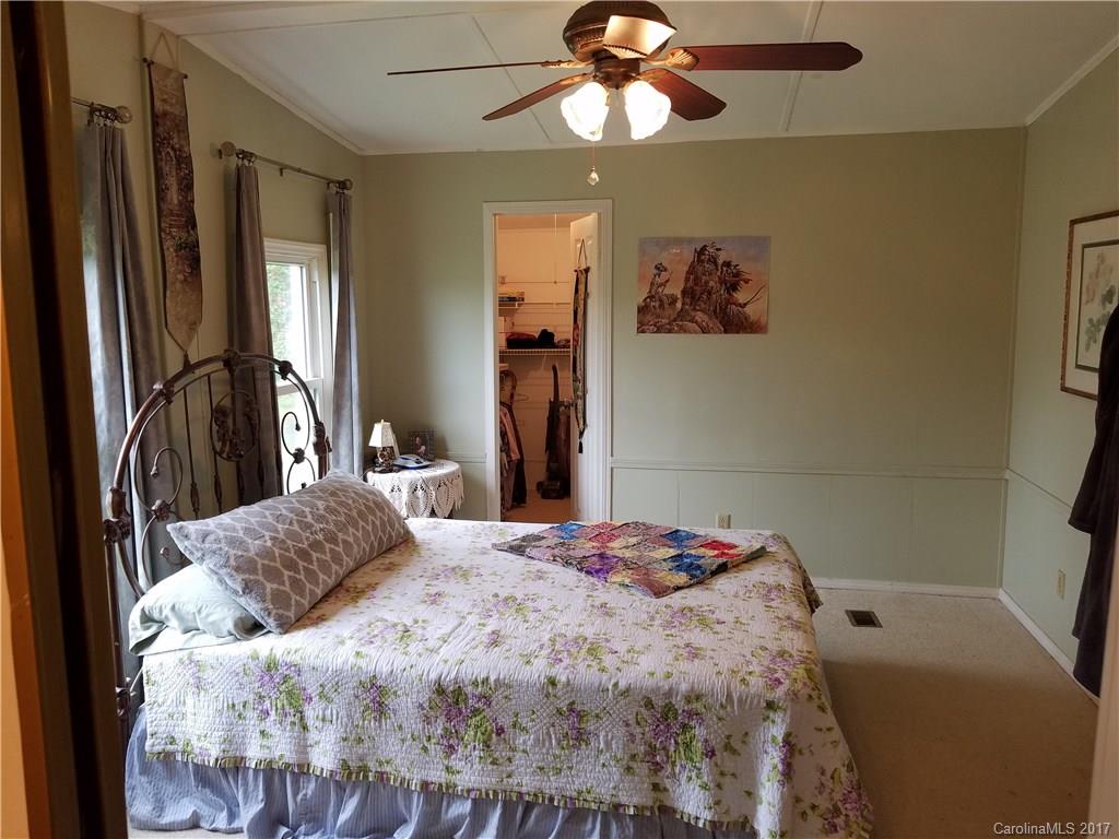 433 Abel Road Canton, NC 28716 - Photo 13 of 18 a bedroom with a bed and a chandelier