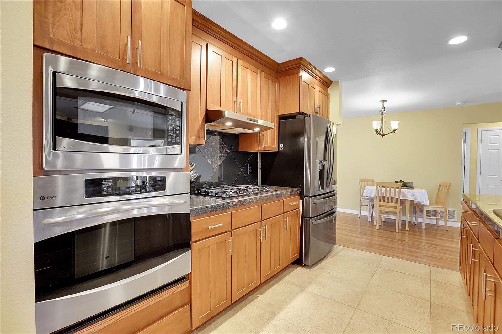 7539 East Easter Place Centennial, CO 80112 - Photo 12 of 40 a kitchen with stainless steel appliances a stove a microwave and a refrigerator