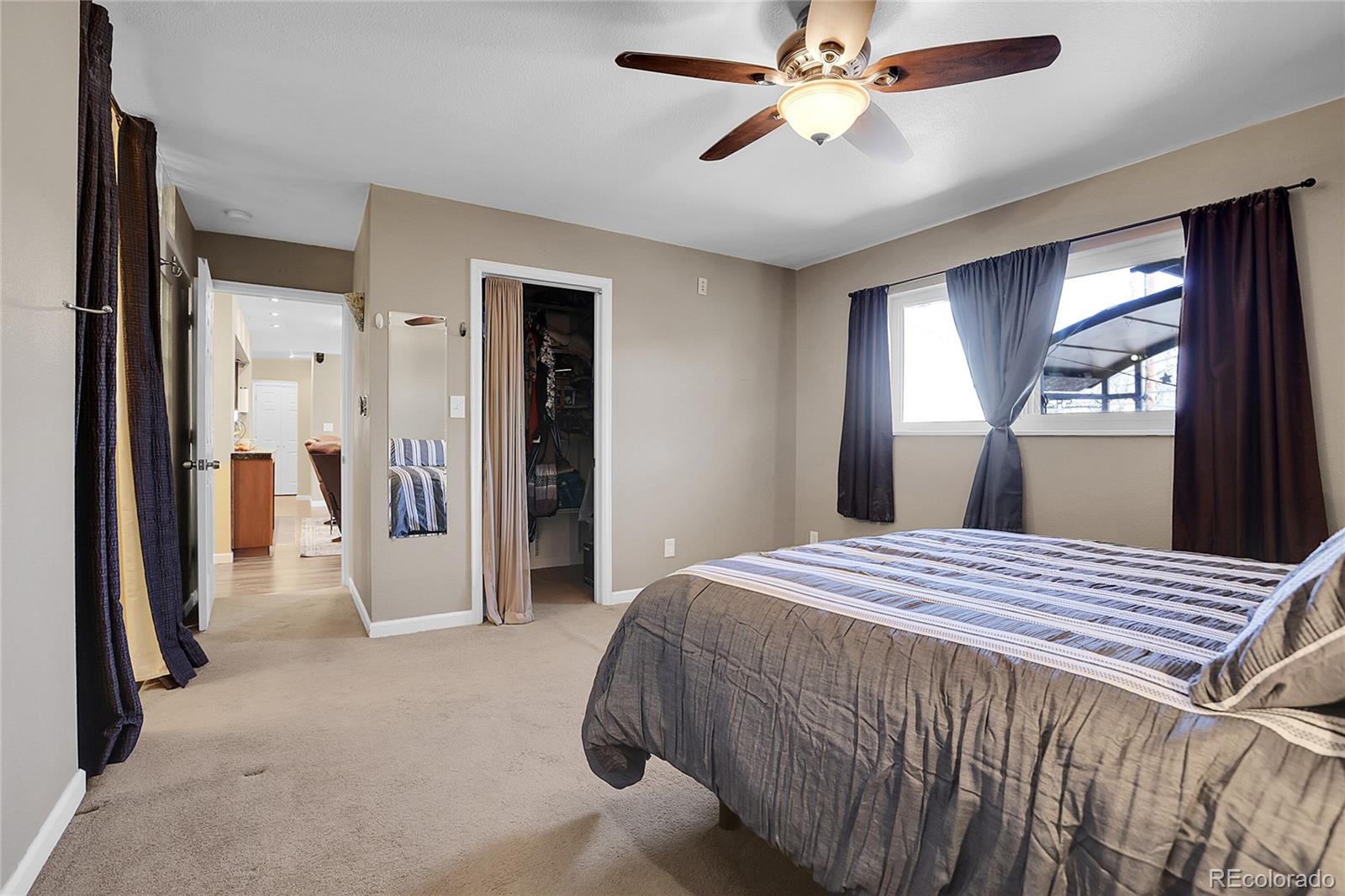 7539 East Easter Place Centennial, CO 80112 - Photo 19 of 40 a bedroom with a bed and a chandelier