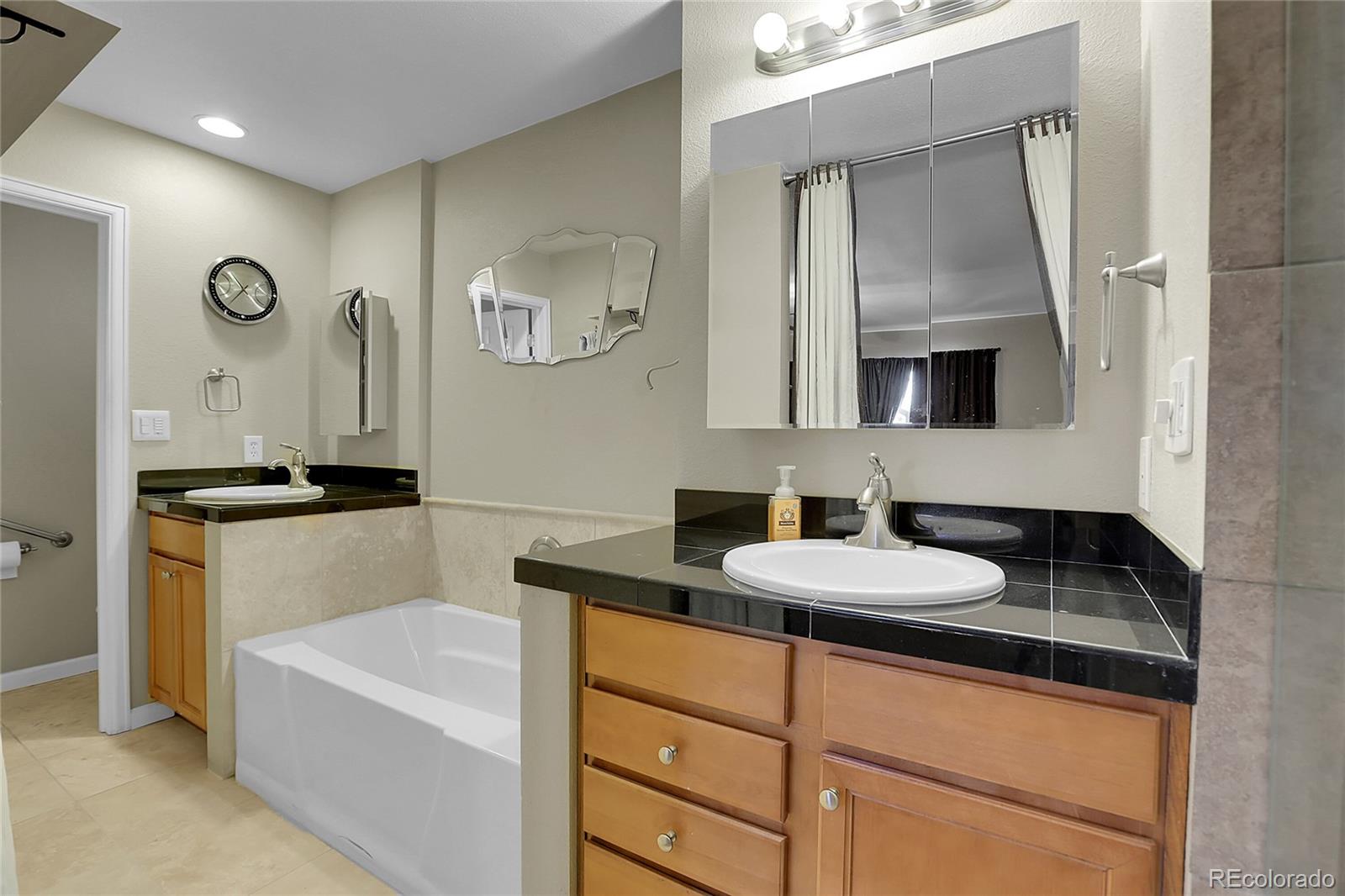 7539 East Easter Place Centennial, CO 80112 - Photo 20 of 40 a bathroom with a granite countertop sink mirror and a bathtub