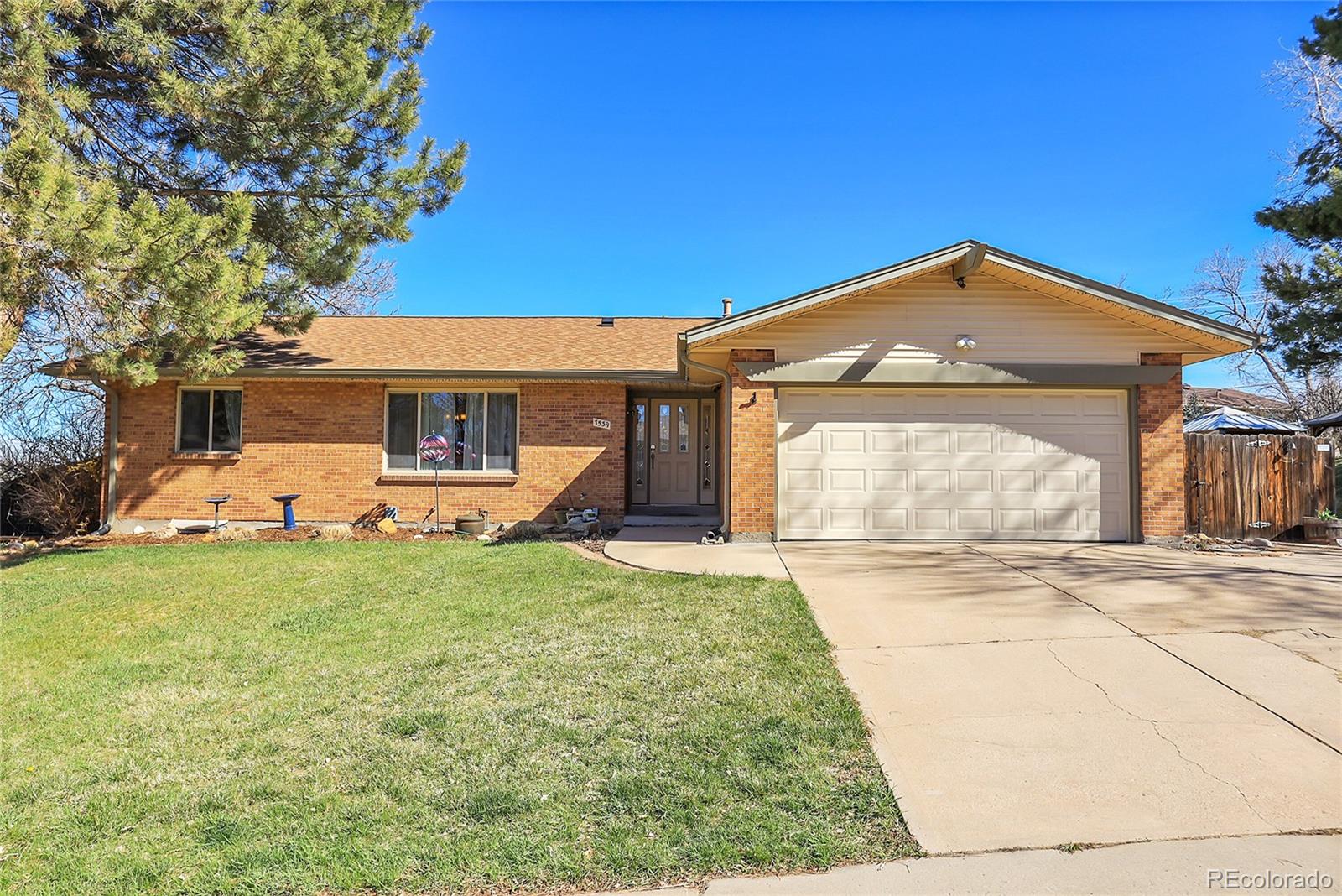 7539 East Easter Place Centennial, CO 80112 - Photo 2 of 40 a front view of a house with a yard and garage