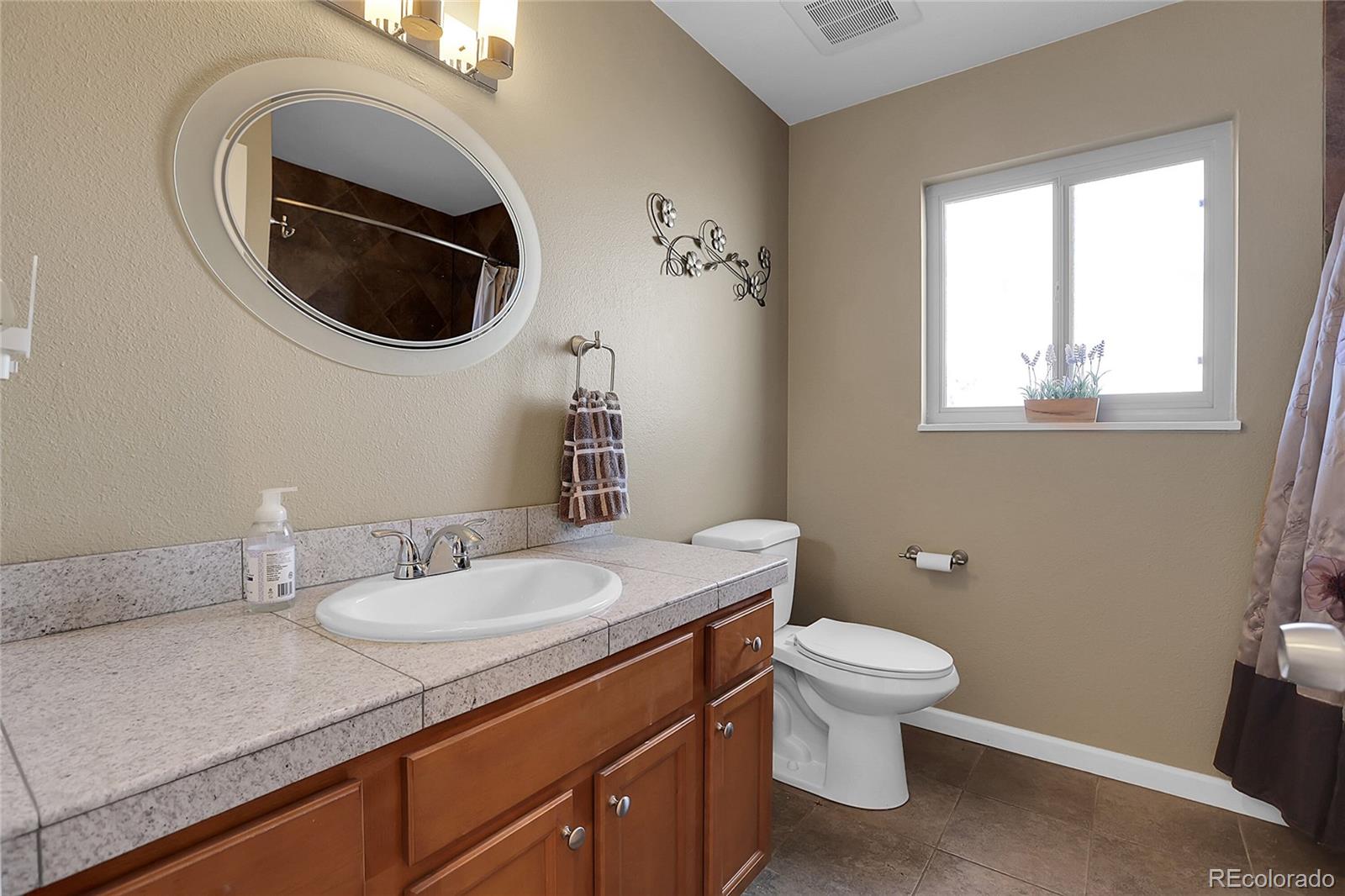7539 East Easter Place Centennial, CO 80112 - Photo 24 of 40 a bathroom with a toilet a sink and a mirror