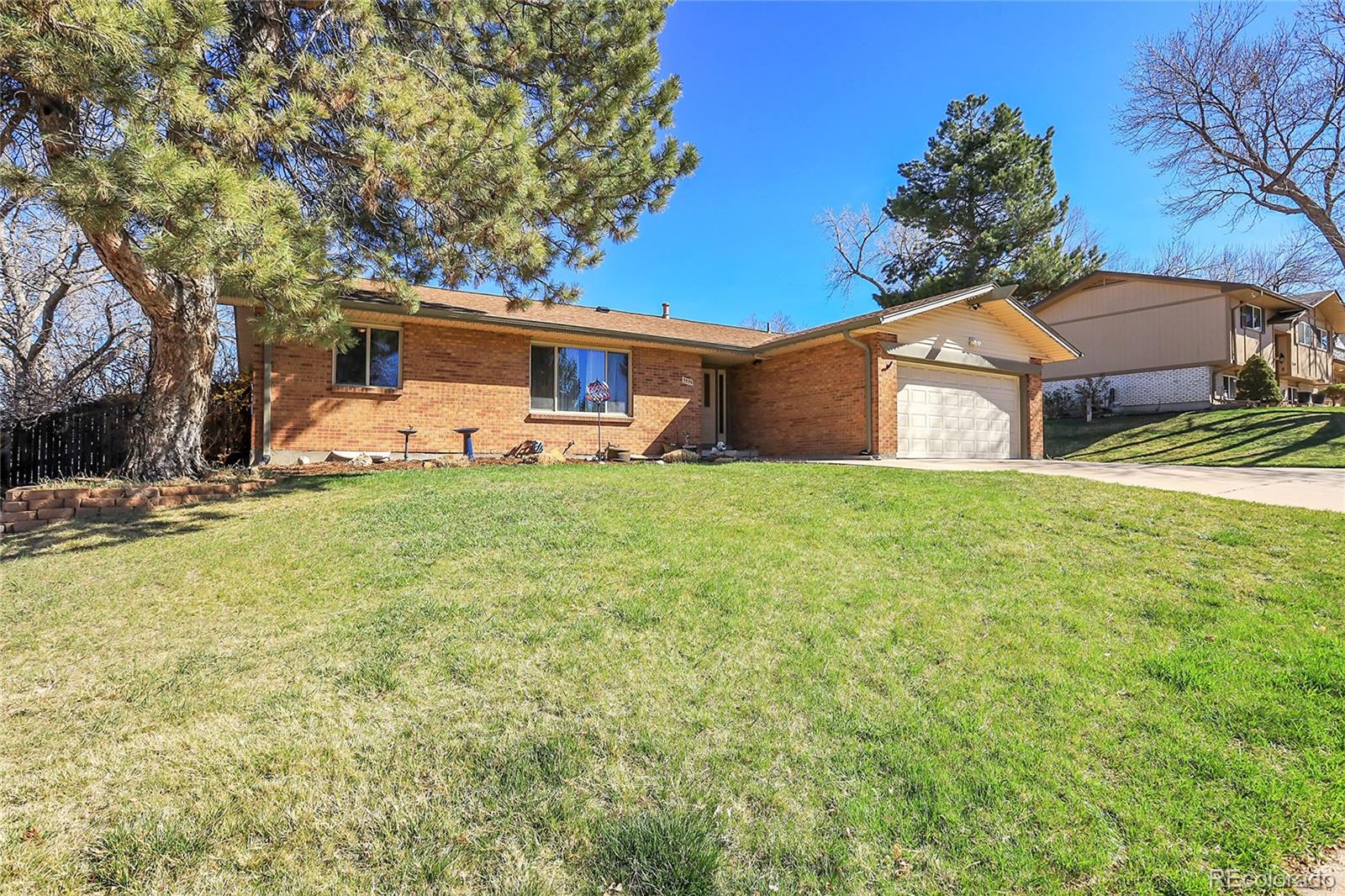 7539 East Easter Place Centennial, CO 80112 - Photo 3 of 40 a front view of a house with a yard and garage