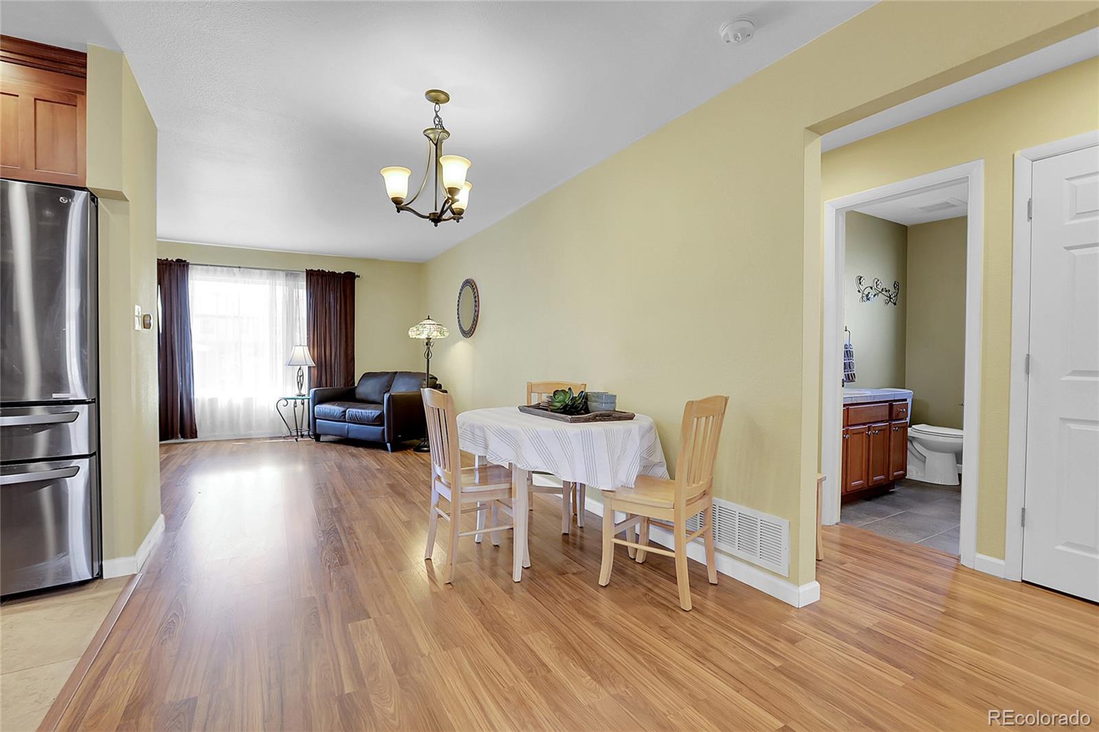 7539 East Easter Place Centennial, CO 80112 - Photo 8 of 40 a living room with furniture dining table wooden floor and a refrigerator