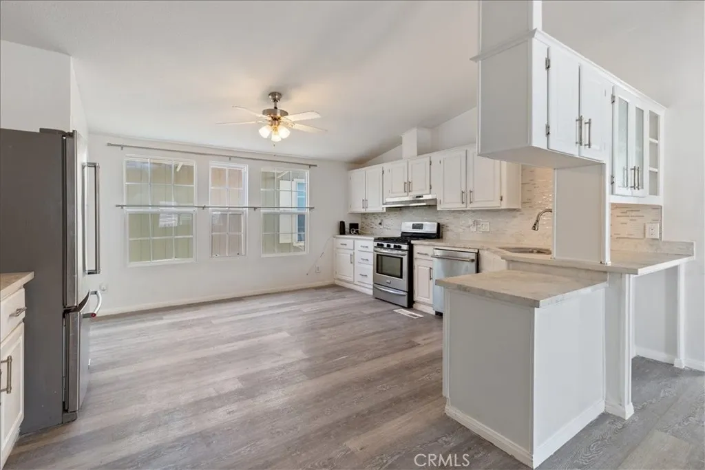 9080 Bloomfield Avenue, Unit 237 Cypress, CA 90630 - Photo 5 of 24 a kitchen with granite countertop a stove a sink and a refrigerator