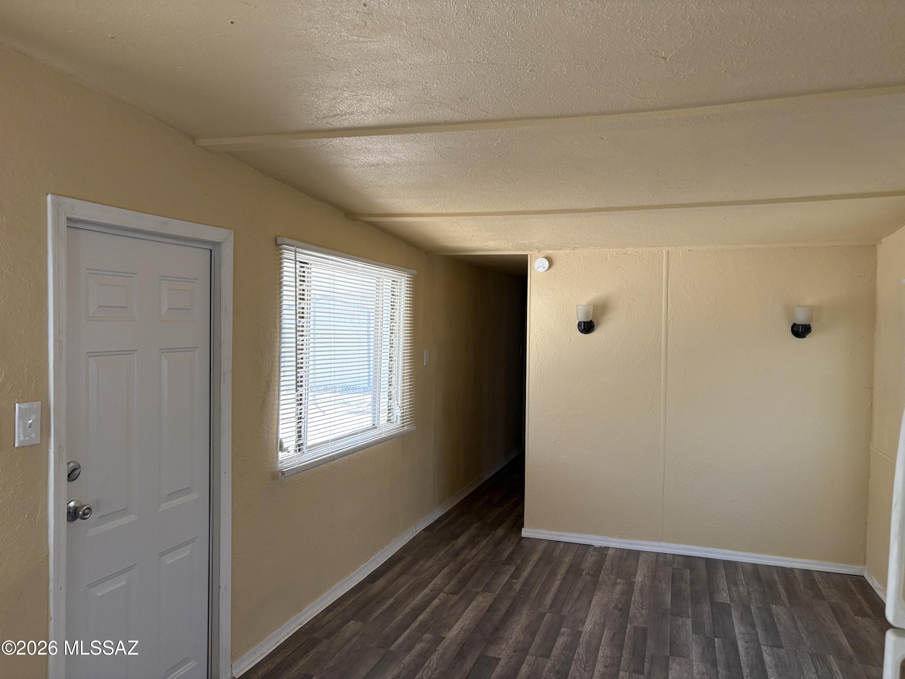 1741 West Wetmore Road, Unit 29 Tucson, AZ 85705 - Photo 5 of 10 a view of an empty room with wooden floor and a window
