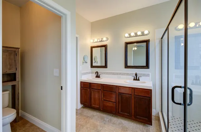 a bathroom with a toilet a sink and mirror