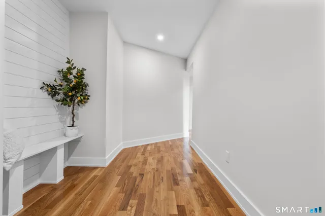 a view of a room with wooden floor and a potted plant