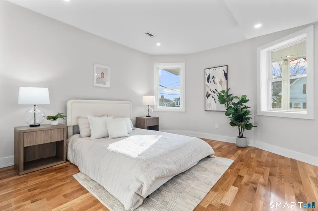 a bedroom with a large bed and a potted plant